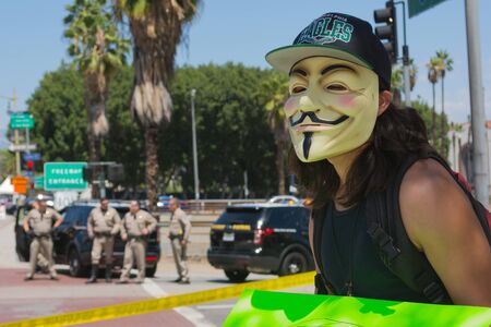 Los Angeles CA USA  May 02 2015: Anonymous with mascara with police in the background during march against the death of Freddie Gray a man of Baltimore who was seriously injured in police custody.のeditorial素材