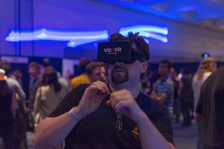 Los Angeles, CA - USA - August 29, 2015: Guy tries virtual glasses headset during VRLA Expo, virtual reality exposition, event at the Los Angeles Convention Center in Los Angeles.のeditorial素材