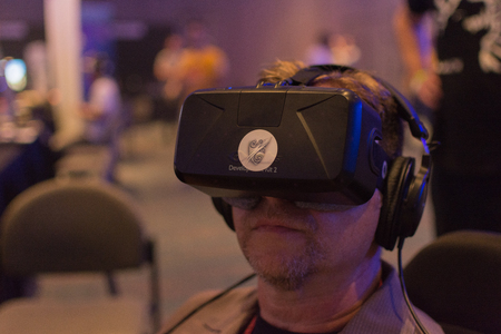Los Angeles, CA - USA - August 29, 2015: Guy tries virtual glasses headset during VRLA Expo, virtual reality exposition, event at the Los Angeles Convention Center in Los Angeles.のeditorial素材