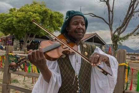 Irwindale, CA - USA - May 07, 2016: Man with medieval costume fiddling during The 54th Annual Renaissance Pleasure Faire.のeditorial素材