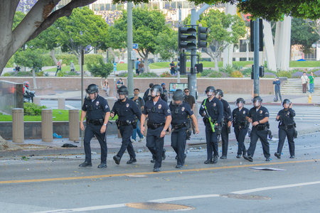 Los Angeles, USA â June 8, 2025: Police officers marching in formation during a downtown demonstration against expanded ICE operations and in support of immigrant rightsの写真素材