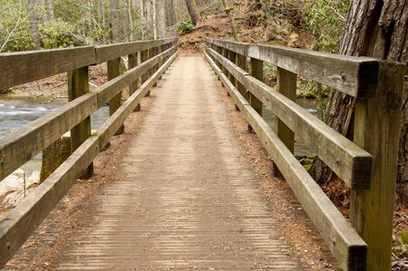 Wooden brdige spans a small stream.
