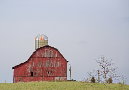 Scenic red barn surrounded with big sky.の写真素材