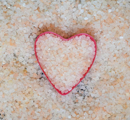 Himalayan salt in the shape of a heart top view. Pink salt crystals. Healthy food concept.の写真素材