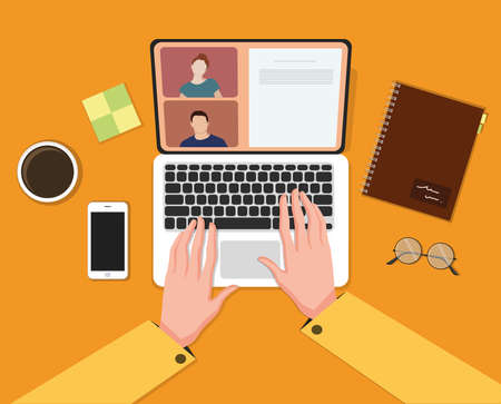 Hands using laptop, desk, coffee, notebook.