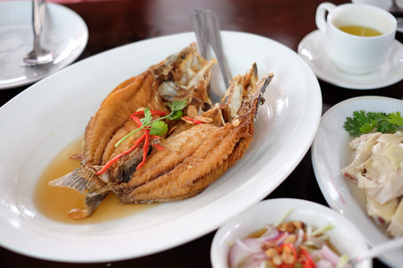 Deep fried snapper topped with fish sauce, Thai food.の写真素材