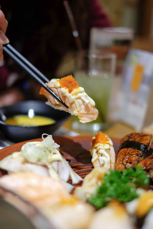 Grilled salmon sushi in chopsticks, Japanese cuisine.の写真素材