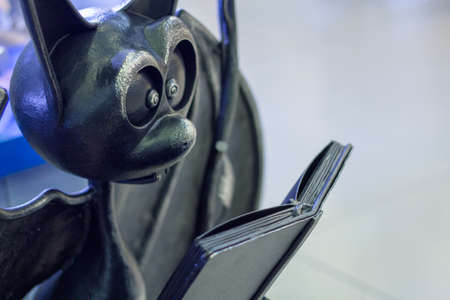 Moscow, Russia, March 23, 2020: Bat figurine is reading a book. Bronze figurine.
