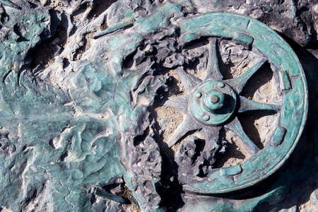 Details of an artillery gun. The surface of the stone. Background of military equipment. Close-up