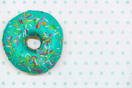 Turquoise donut with glaze on a white-turquoise background copy space