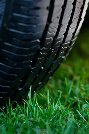 wet wheel on the green grass with dewの写真素材