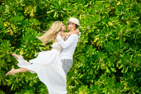 happy couple is turned on the background of tropical palm treesの写真素材
