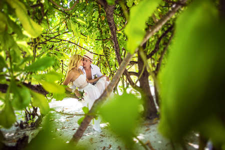Young couple honeymooning in the Maldives. They are kissing.の写真素材