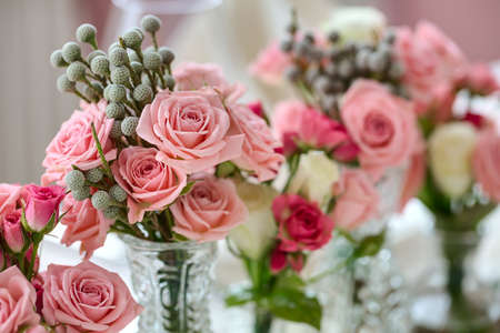 Bouquets of roses on a festive wedding table in the restaurant.の写真素材