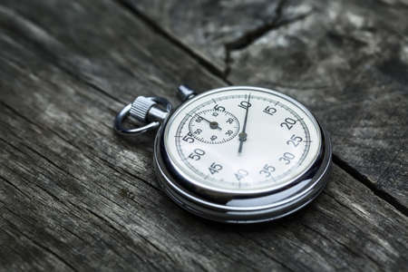 Steel stopwatch on the old textured gray wooden surface.の写真素材
