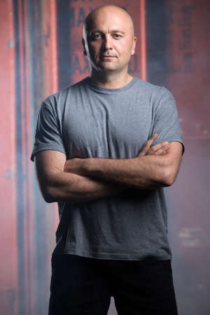 Portrait of a charismatic bald athlete. Studio shot in the dark tone.の写真素材