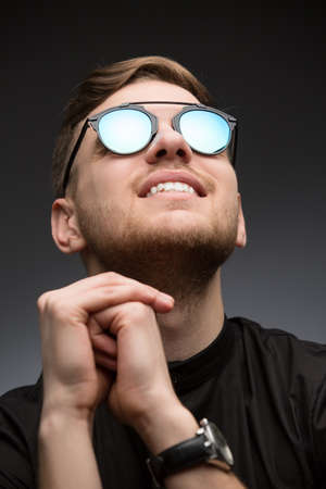 Portet young guy in mirrored sunglasses. Studio shot.