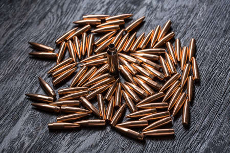 Placer copper bullets on a dark wooden background, shot in the studio.の写真素材