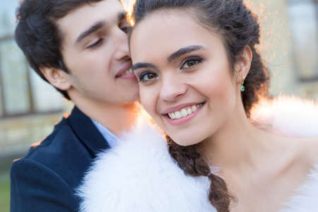 Close portrait of happy wedding couple. Newlyweds outdoors at sunset.の写真素材