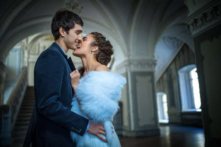 Portrait of happy wedding couple in classic interior. Newlyweds embracing in front of a kiss.の写真素材