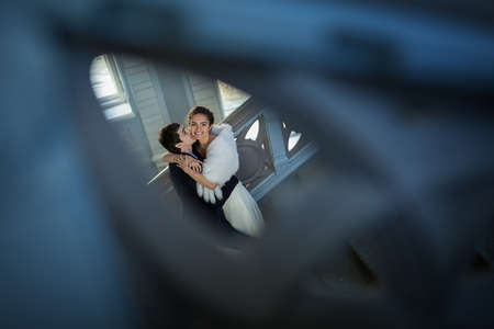 Kissing couple in love standing on a ladder. Taken over the railing of the upper floors.の写真素材