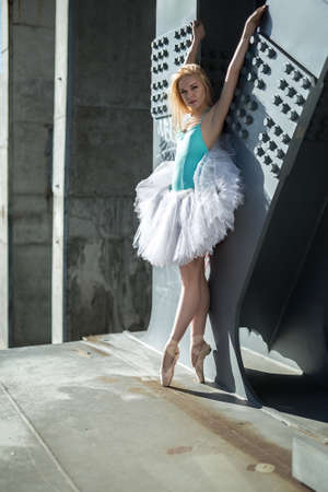 Graceful ballerina in white tutu in the industrial background of the bridge.の写真素材