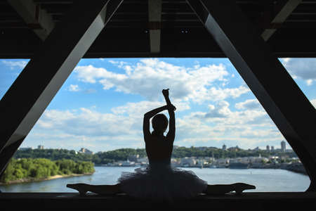 Silhouette of graceful ballerina in white tutu on a background of green slopes of the Dnieper Kiev. Ukraine.の写真素材