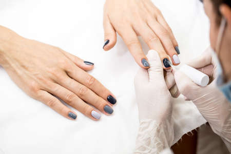 Photos of manicure at the salon. Master gets a new paint gray fingers on different - different shades.の写真素材