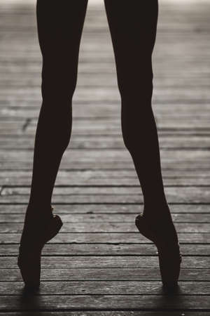 Photo of graceful ballerina dancing feet on the floor in backlit.の写真素材