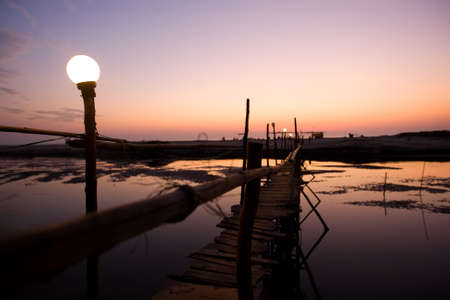 sunset in goa, wooden bridge over riverの写真素材