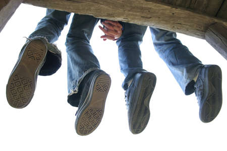 Legs of Couple sitting on the wooden benchの写真素材