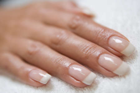 womans hand with a french manicure on the towelの写真素材