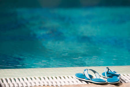 two blue slippers near swimming pool in hotelの写真素材
