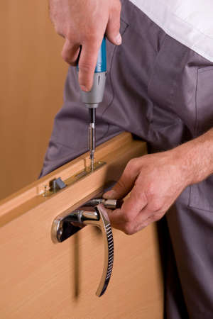 man's hands is exchanging lock for the doorの写真素材