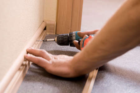 man is fixing plinth in the room