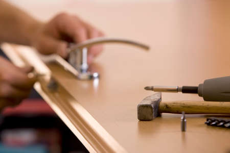 man's hands is exchanging lock for the doorの写真素材