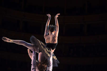 Prima ballerina dancing at a rehearsal on the stage in a performance of Swan Lake with the support...