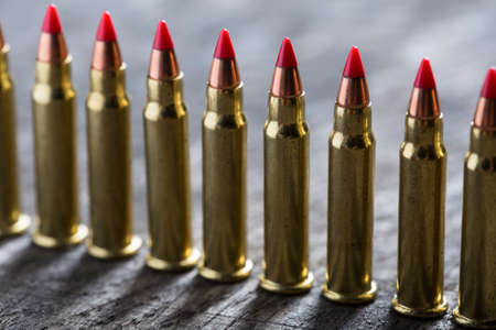Cartridges ranked with red tip on a dark wooden backgroundの写真素材