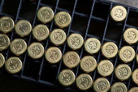 Scattering of small caliber cartridges on a wooden background. Other cartridges cartridges lies in capsules up. The picture from the top point.の写真素材