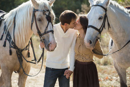 Young couple in love walking in a picturesque place with horses. Weddings are for horses bridle.の写真素材