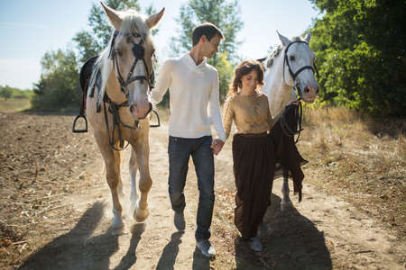 Young couple in love walking in a picturesque place with horses. Weddings are for horses bridle.の写真素材