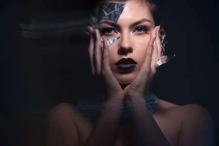 Bewitching portrait of a woman with artistic make-up on her face and neck.She keeps her face. Art...