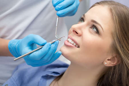Girl with beautiful white teeth on reception at the doctor dentist.の写真素材