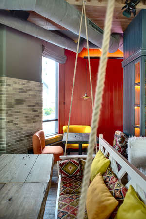 Charming room in a loft style in a mexican restaurant on the background of the red wall. There is a...