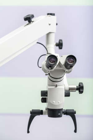 Optical dental microscope on the blurry wall background. Close-up photo. Vertical.の写真素材