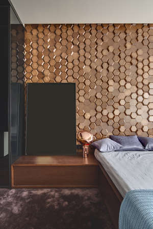 Modern style bedroom with a burgundy carpet on the floor. There is a bed with pillows and a...
