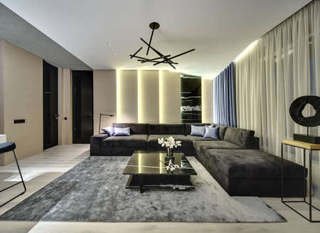 Room in a modern style with wooden walls with a marble part. There is a dark sofa, black marble table with flowers, gray carpet, large window with curtains, doors, wooden stand with decorative figure.の写真素材