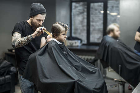 Haircut of small boy in barbershopの写真素材