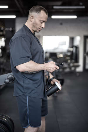 Muscular man has pause in gym