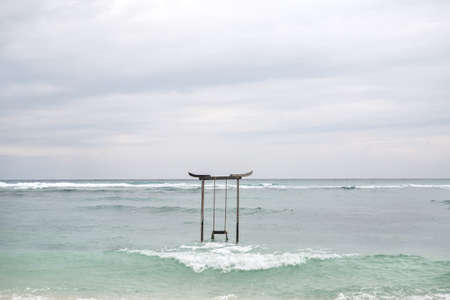 Wooden swing in sea waterの写真素材